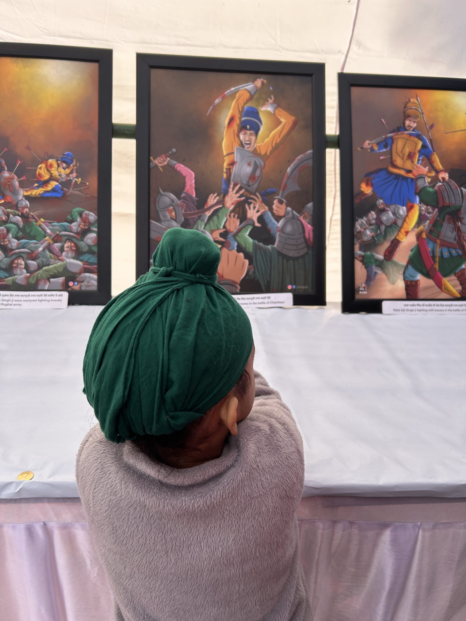 A visitor pausing before a framed Sikh artwork