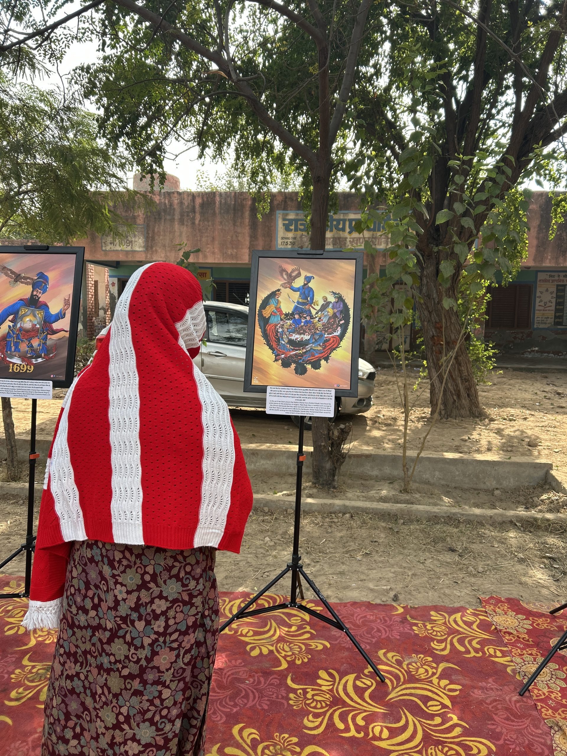 Sangat viewing framed Sikh artworks in the open air