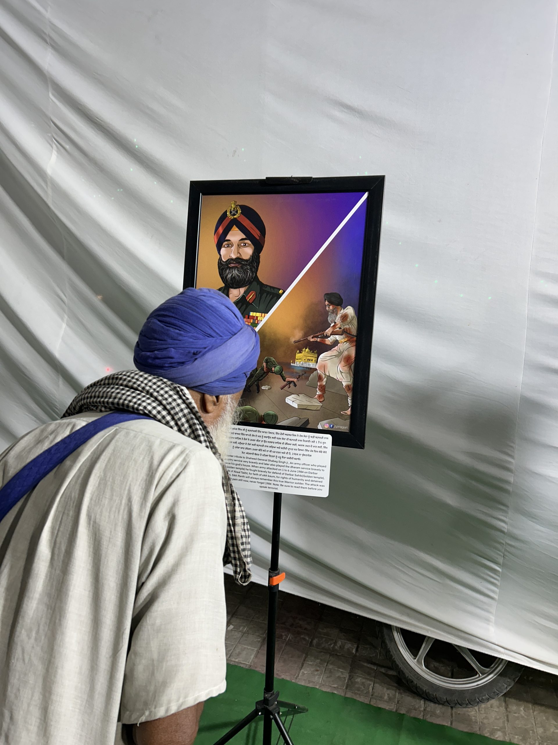 An elder reading the caption beside a June 1984 artwork