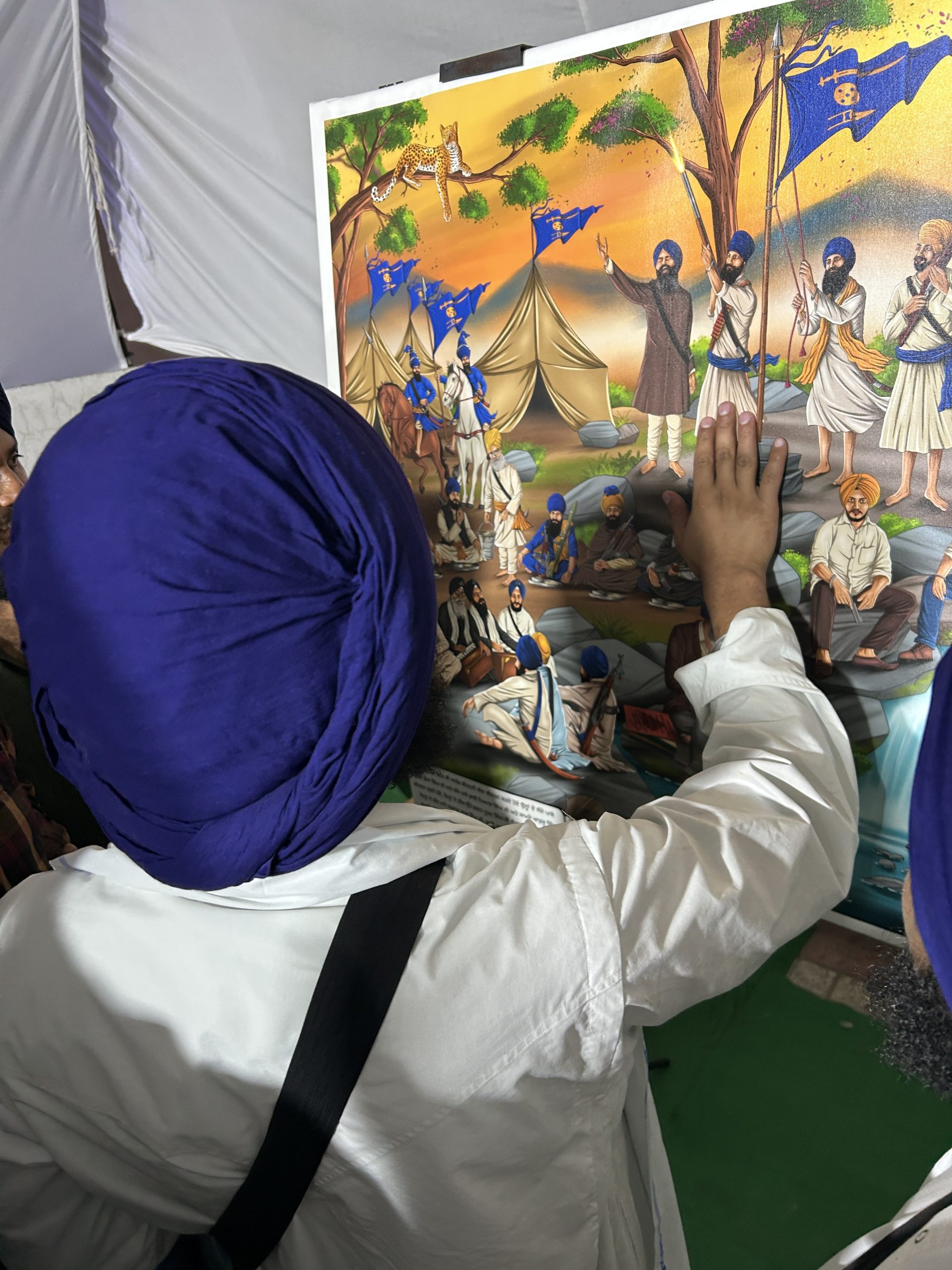 A visitor tracing the Chamkaur scene on a large-format artwork