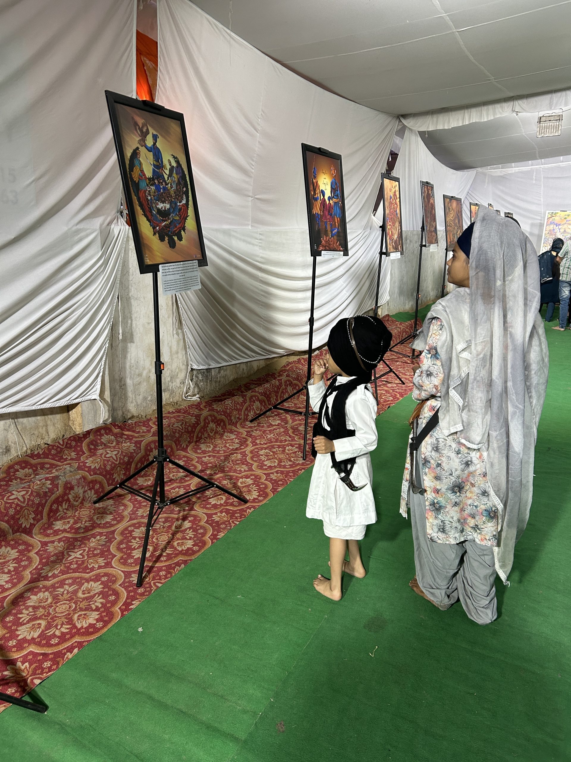Sangat walking through a GS Nagi Sikh art exhibition